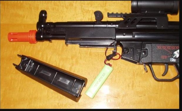 Airsoft AEG rifle with the magazine removed showing the battery pack and connector